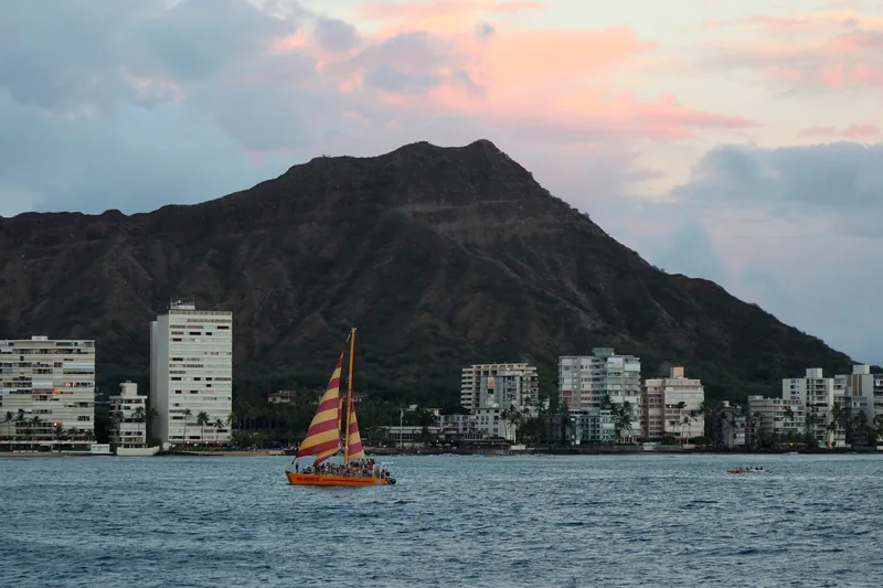 A catamaran under sail off Lēʻahi (Diamond Head) on the south shore
